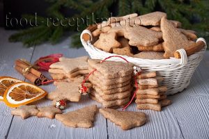 На фото имбирное печенье в белой корзинке и новогодние украшения