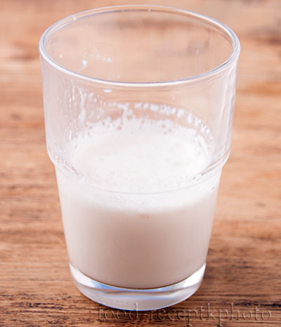 На фото стакан с молоком и разведенными в нем дрожжами