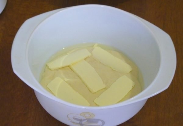 Жидкое тесто и кусочки сливочного масла в жаропрочной форме
