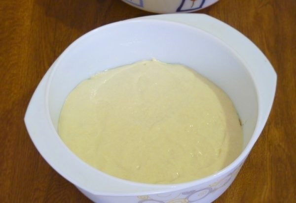 Заготовка для заливного пирога в белой жаропрочной форме на столе