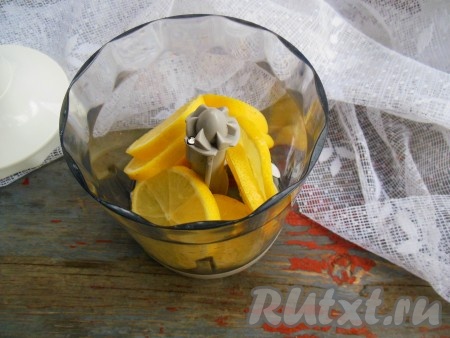 В чашу блендера с насадкой "нож" выложите колечки лимона. 
