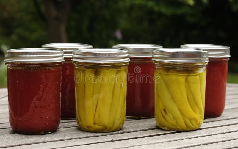 Home canned tomato sauce and pickled peppers. royalty free stock photography