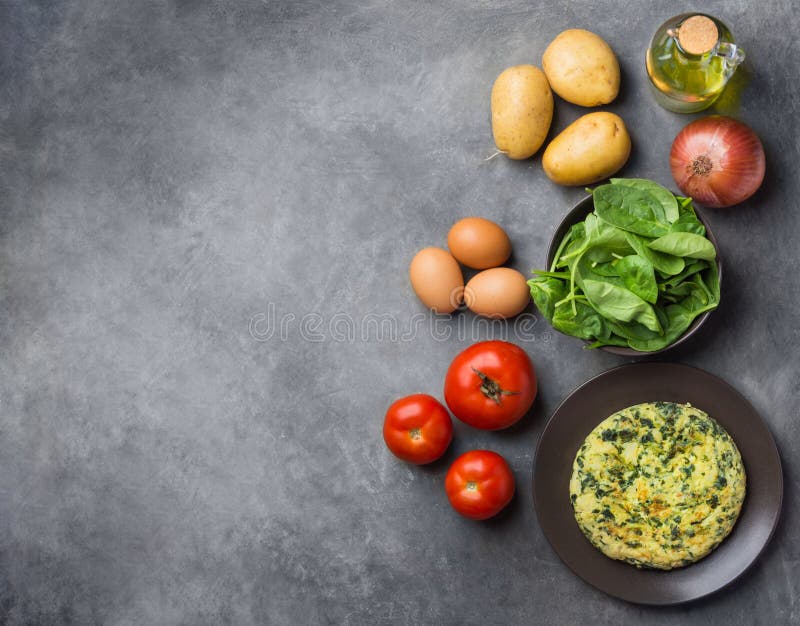 Homemade delicious frittata with spinach on plate. Recipe ingredients potatoes eggs olive oil in bottle tomatoes on dark concrete royalty free stock photos