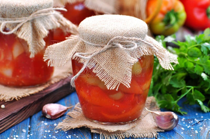 Pickled peppers in tomato juice with onions, garlic and basil. royalty free stock photography