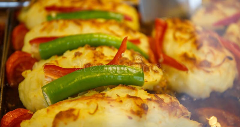 Potatoes with cheese, tomatoes and green pepper. stock photography