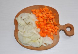 В чашу мультиварки влить масло, выставить режим выпечки на полчаса. Нарезать, как обычно для заправки, луковицы, сельдерей и морковки, выложить в чашу, перемешать, оставить жариться 5-7 минут, периодически помешивая.