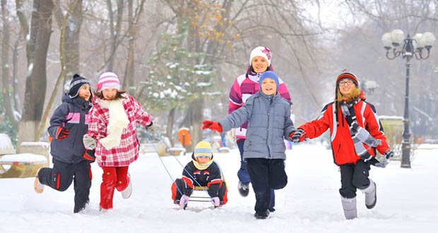 Дети зимой катаются на санках