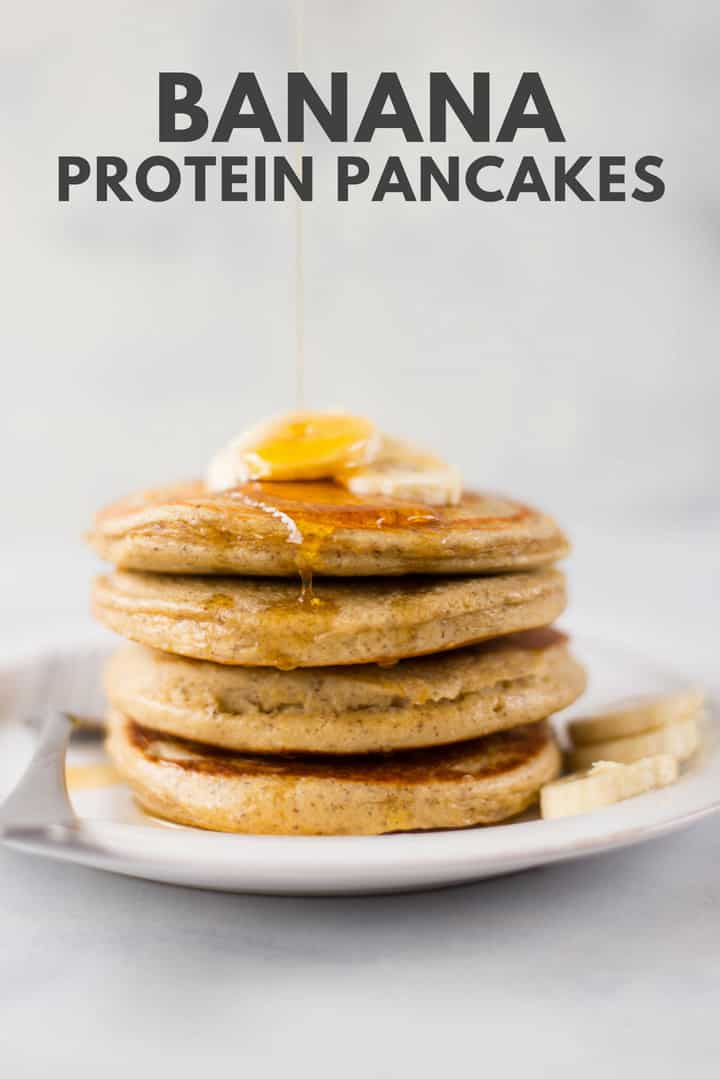 A side image of a stack of Banana Protein Pancakes made with eggs, egg whites, bananas, uncooked rolled oats, baking powder, sea salt, ground cinnamon, vanilla or unflavored protein powder and ground flaxseeds, topped with banana slices and drizzled with maple syrup.