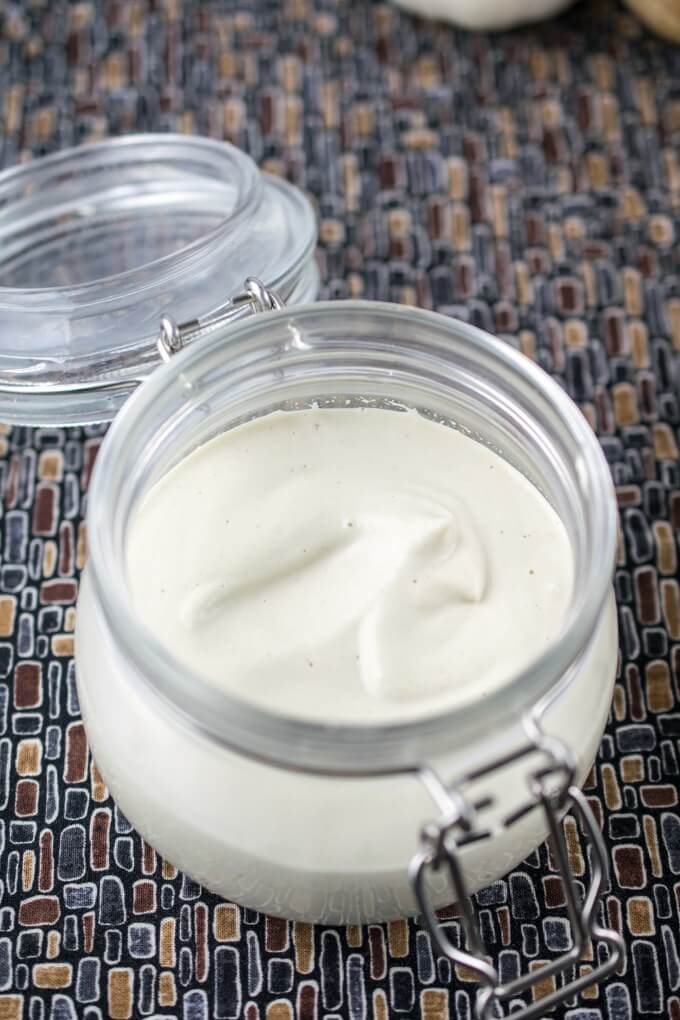 An open jar of oil-free vegan mayo on a patterned napkin